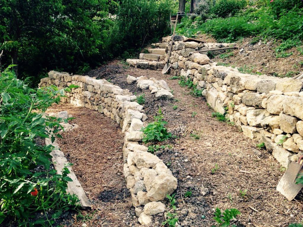 Murs en pierres sèches encadrant un chemin de jardin en pente